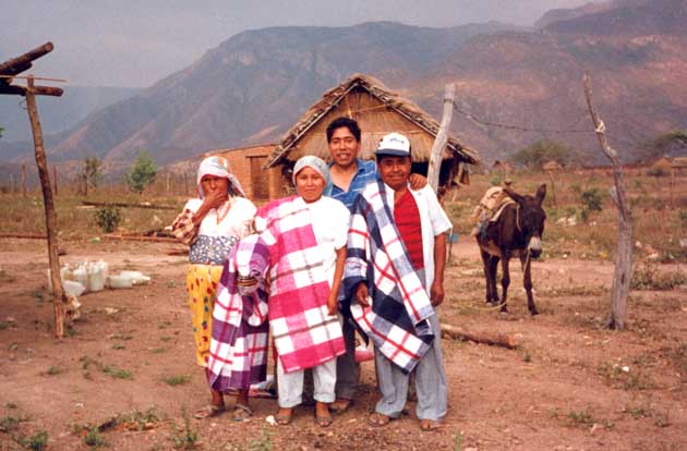 Latin american christian missionary and his family in front of their house
