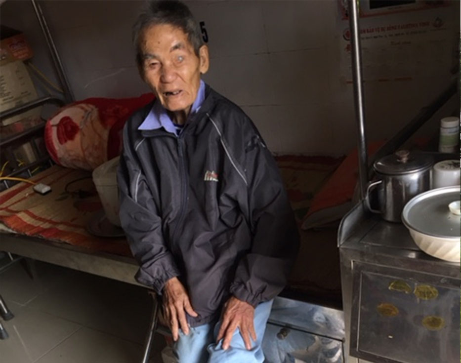 Vietnamese man sits on his bed