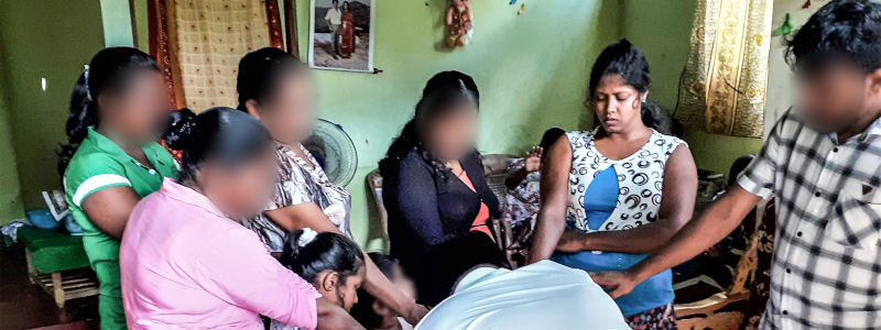 Sri Lankan Christians lay hands on another person and pray
