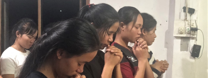 Christian Vietnamese teenage girls pray together
