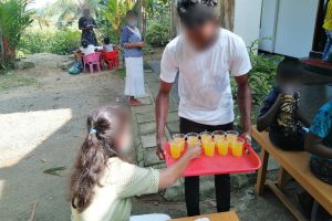 Sri Lankan Christian teen gives girl cup of orange juice