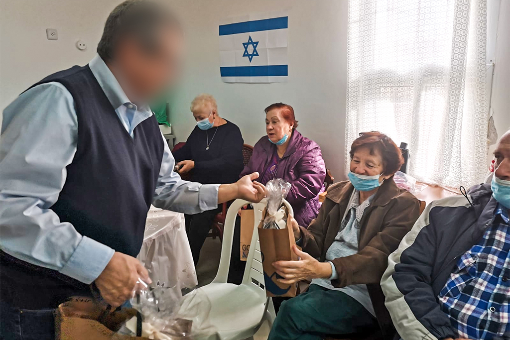 Christian missionary handing bag of goods to an older Jewish lady in Israel