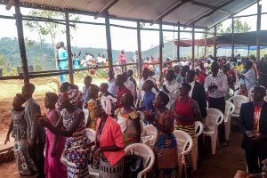 Burundian Christians gather for church in a pavilion made of wood with a tin roof