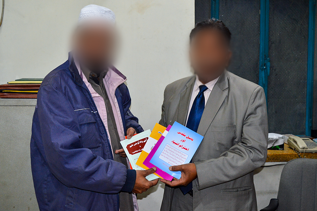 Pakistani church members holding bible related resources