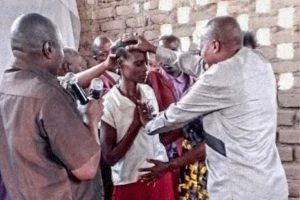 Christian men from Burundi lay hands on a woman while praying for her