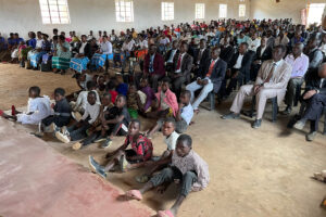 Malawian Christians sitting in rows of plastic chairs in their church building for Sunday service