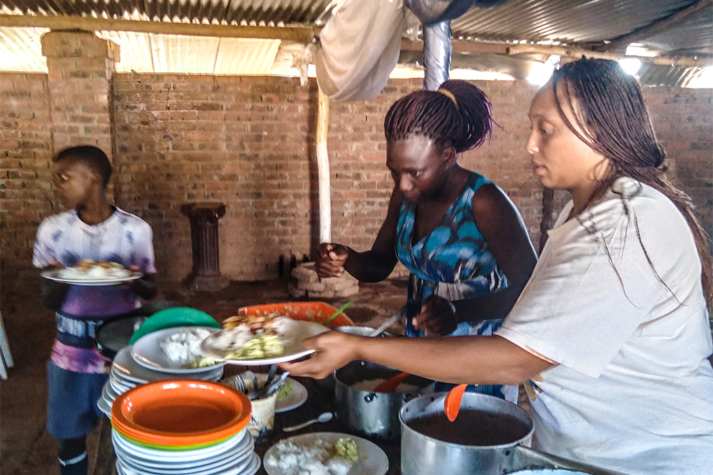 Two Zimbabwean women serving lunch to children at school