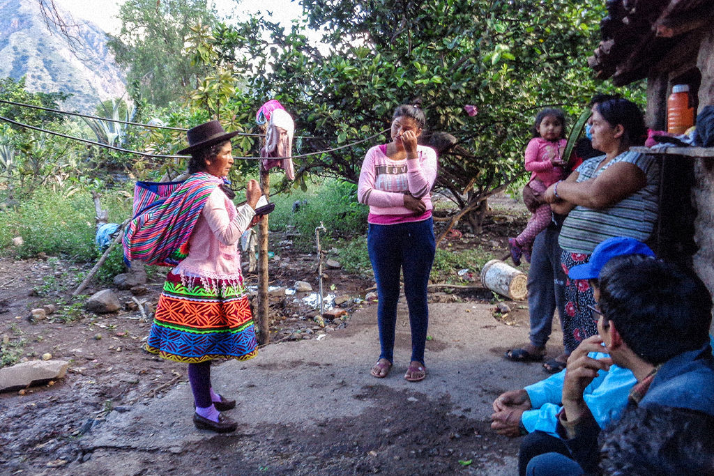 Peruvian woman with a sling hung over her shoulders and a bible in her hand shares the gospel with others