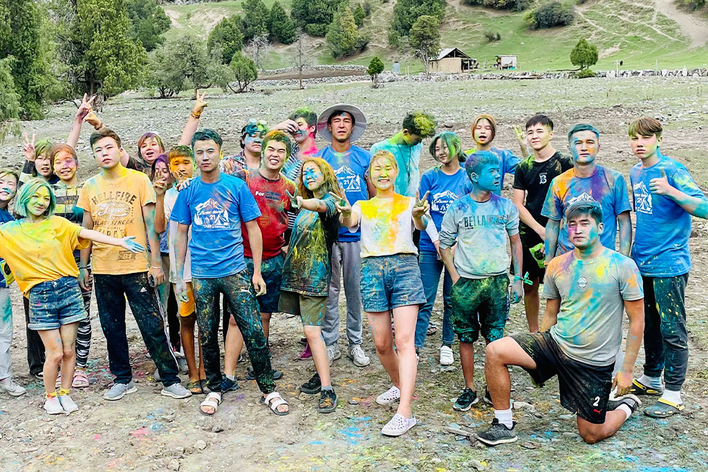 Kyrgyz teenagers covered in yellow and blue paint after a youth group paint war