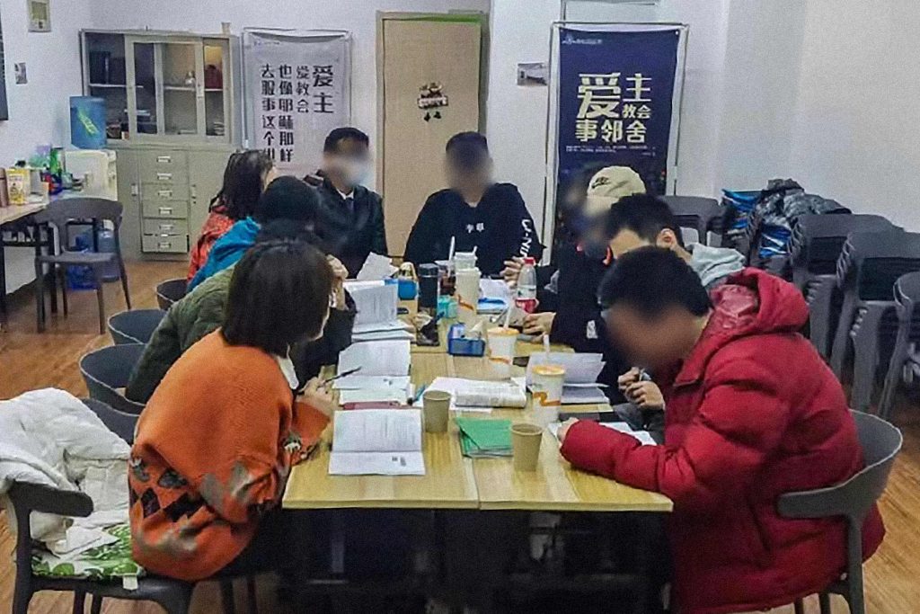 Chinese Christian gathered together in an apartment sitting at a table for a bible study
