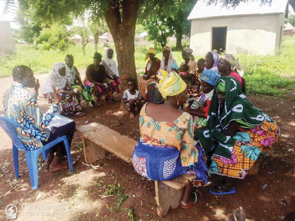 Christians in Ghana sitting under a tree for a Bible study from a missionary