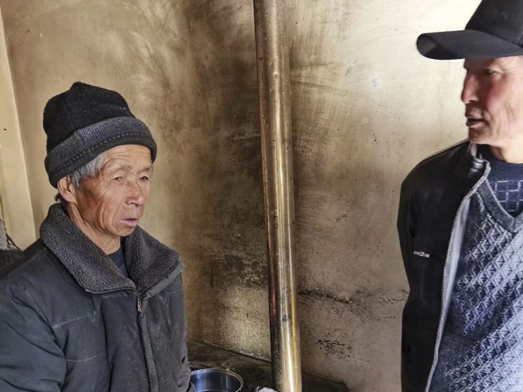 Villager in China wearing hat and jacket talking to Christian missionary