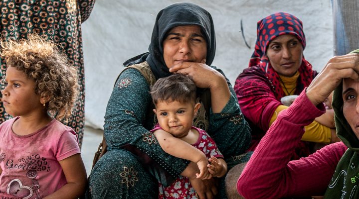 Turkish refugee mothers and their children sitting in a refugee camp in Greece